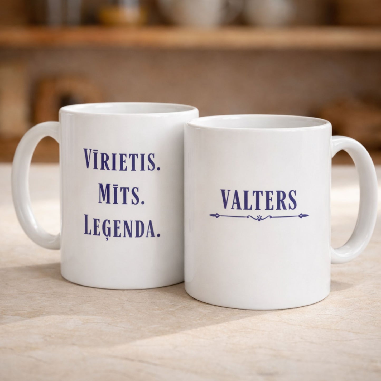 Divas baltas keramikas krūzes ar uzrakstu "Vīrietis. Mīts. Leģenda." un personalizētu vārdu uz virtuves fona