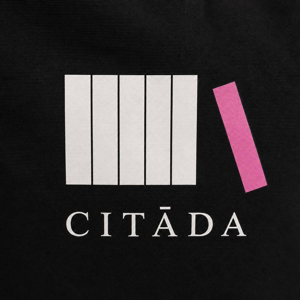 Baltās un rozā HTV apdrukas “Citāda” tuvplāns uz melna kanvas auduma