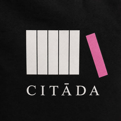 Baltās un rozā HTV apdrukas “Citāda” tuvplāns uz melna kanvas auduma