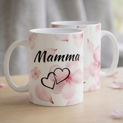 Divas baltas krūzes novietotas viena aiz otras, parādot gan priekšpuses uzrakstu "Mamma", gan estētisko ziedu rakstu no abām pusēm.