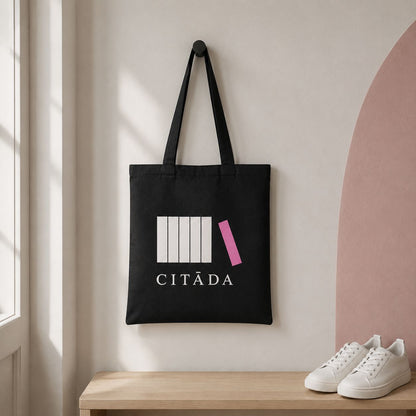 Melna kanvas soma “Citāda” pie sienas āķa gaišā priekšnamā