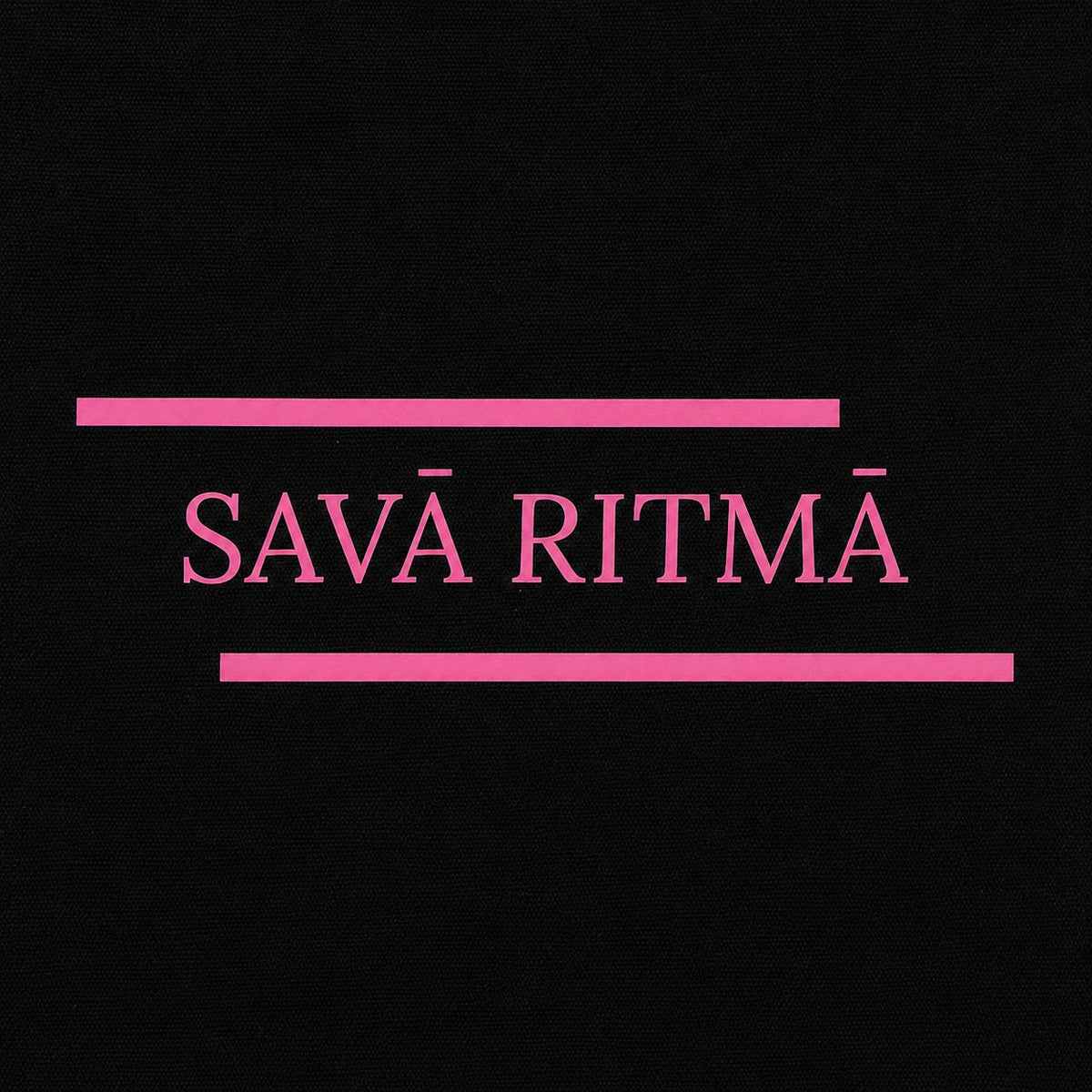 Rozā uzraksta “Savā ritmā” tuvplāns uz izturīgas melnas kanvas somas.